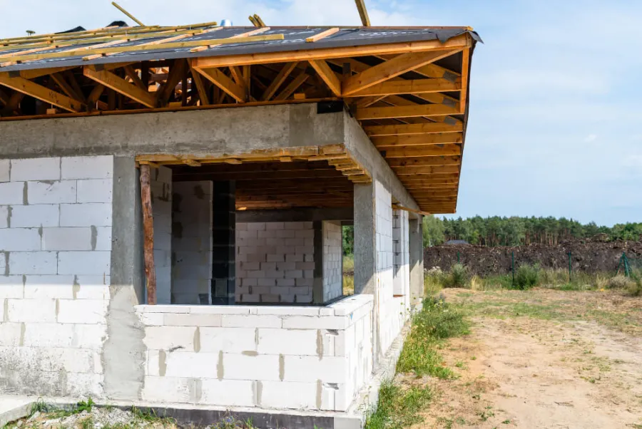 Dom w stanie surowym otwartym — mury i więźba dachowa bez okien i drzwi