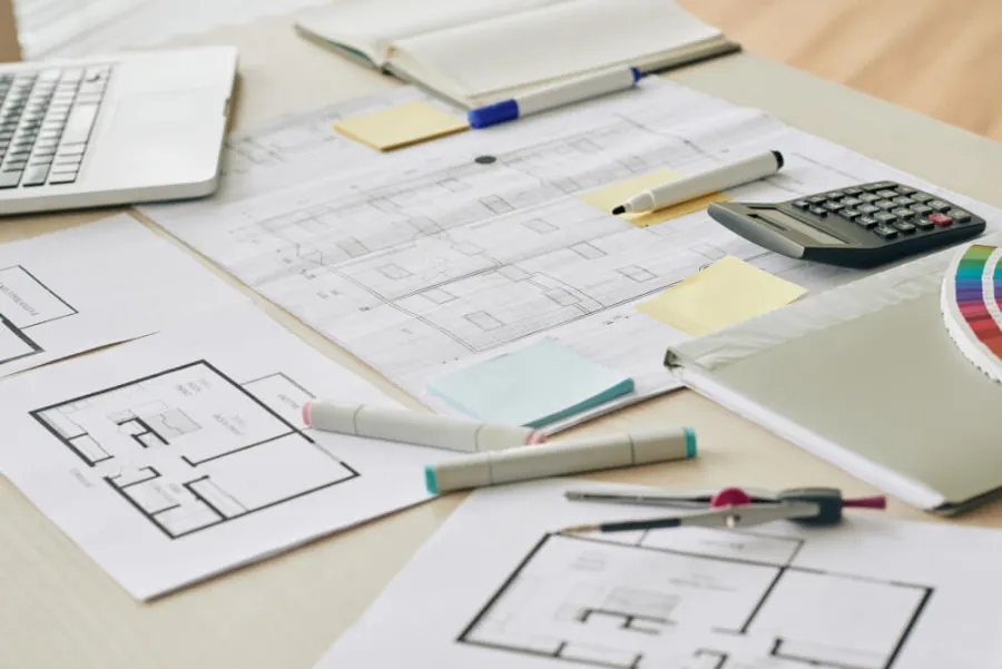 Projekt domu 70m2 — rzut architektoniczny na biurku z narzędziami do rysowania